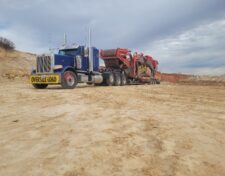 OVERSIZE LOAD banner on the front of a tractor trailer pulling heavy machinery