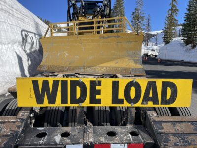 WIDE LOAD sign on the back of a trailer hauling a bulldozer