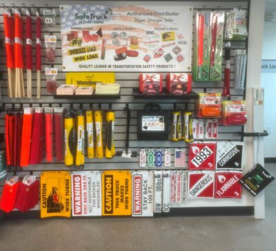 Wall display of truck safety products, oversize load banners, wide load banners, decals and stickers and hazmat placards