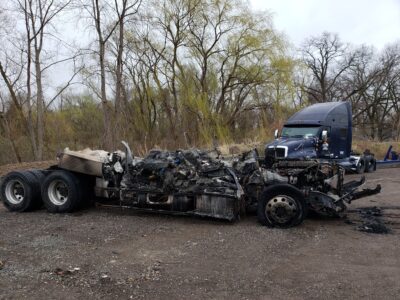 a burnt and destroyed truck chassis in a tow yard